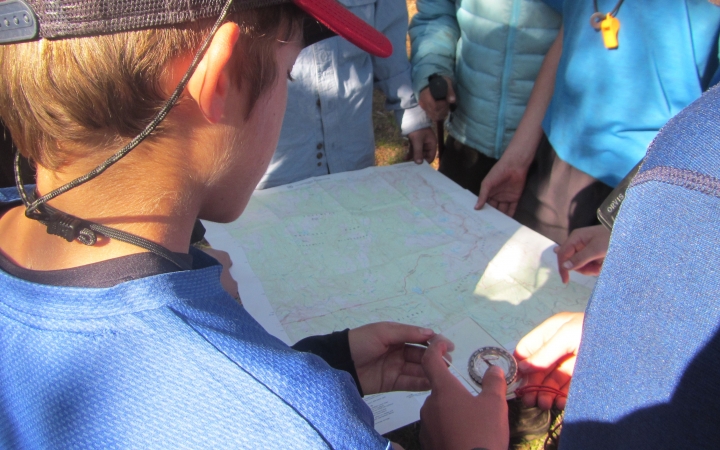an outward bound student uses a map and compass